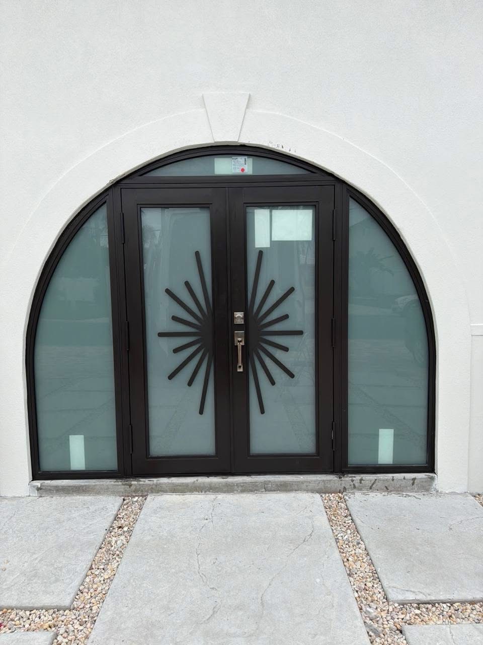 Black door with geometric glass and sidelight panels